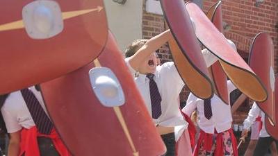 School children playing with shields 